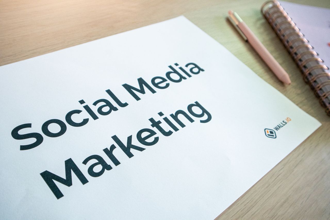 services-01 Detailní záběr na dokument o marketingu na sociálních sítích ležící na stole spolu s perem a zápisníkem.